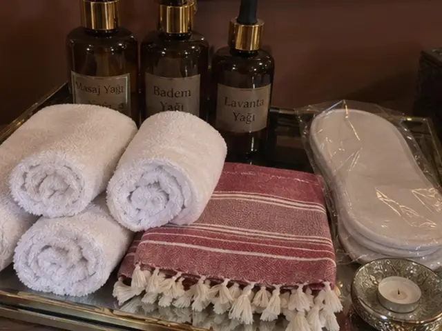 Masaj yağları, rulo havlular, kırmızı çizgili peştemal ve terlik — Levent, Masaj Salonun